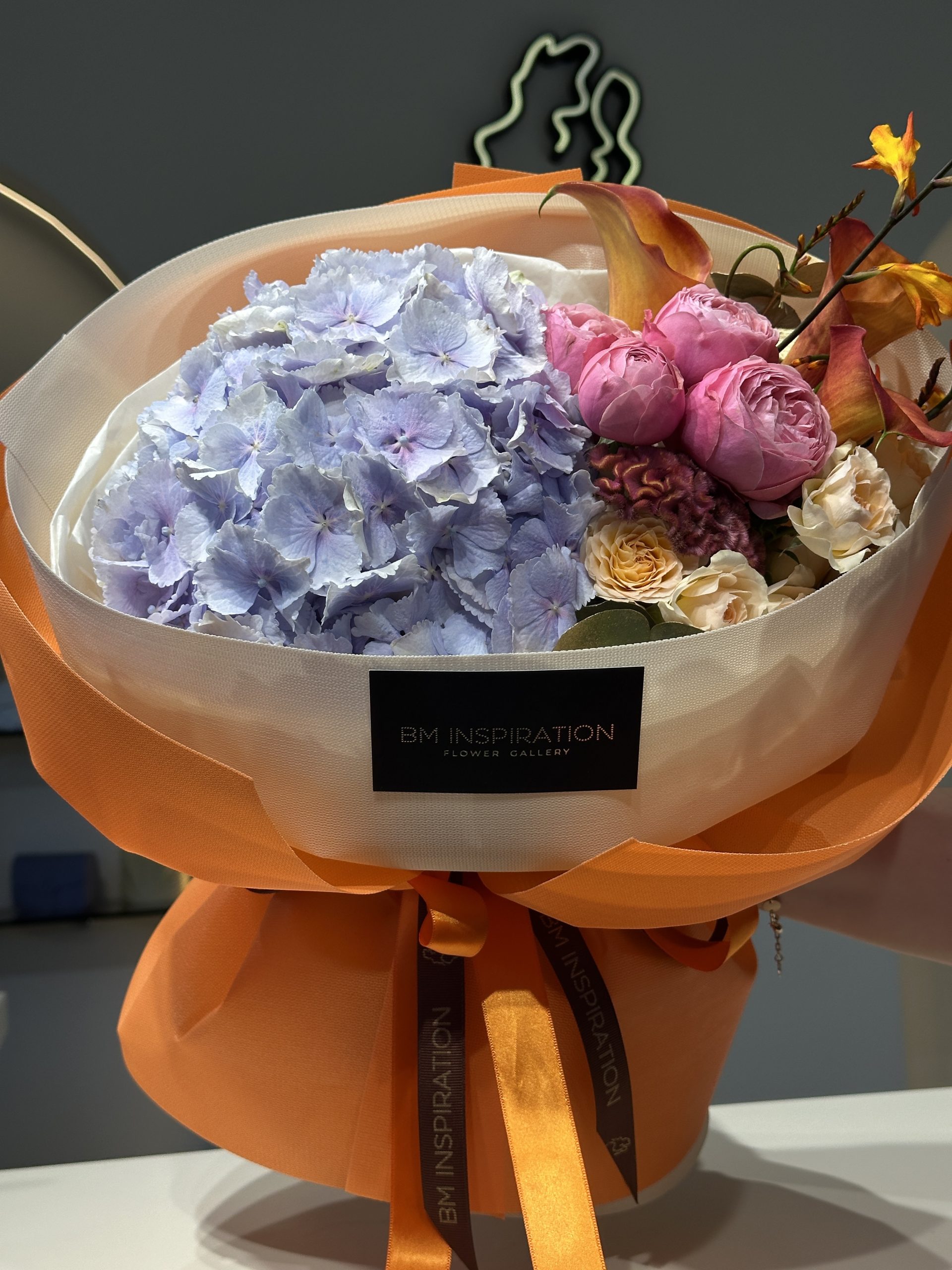 Buchet cu ambalaj, creat în spirală, dintr-un mix de flori premium precum 1 hortensie, crengute de trandafiri, cale, celosia.